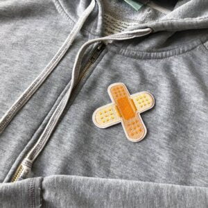 Plaster på såret Strykemerke genser